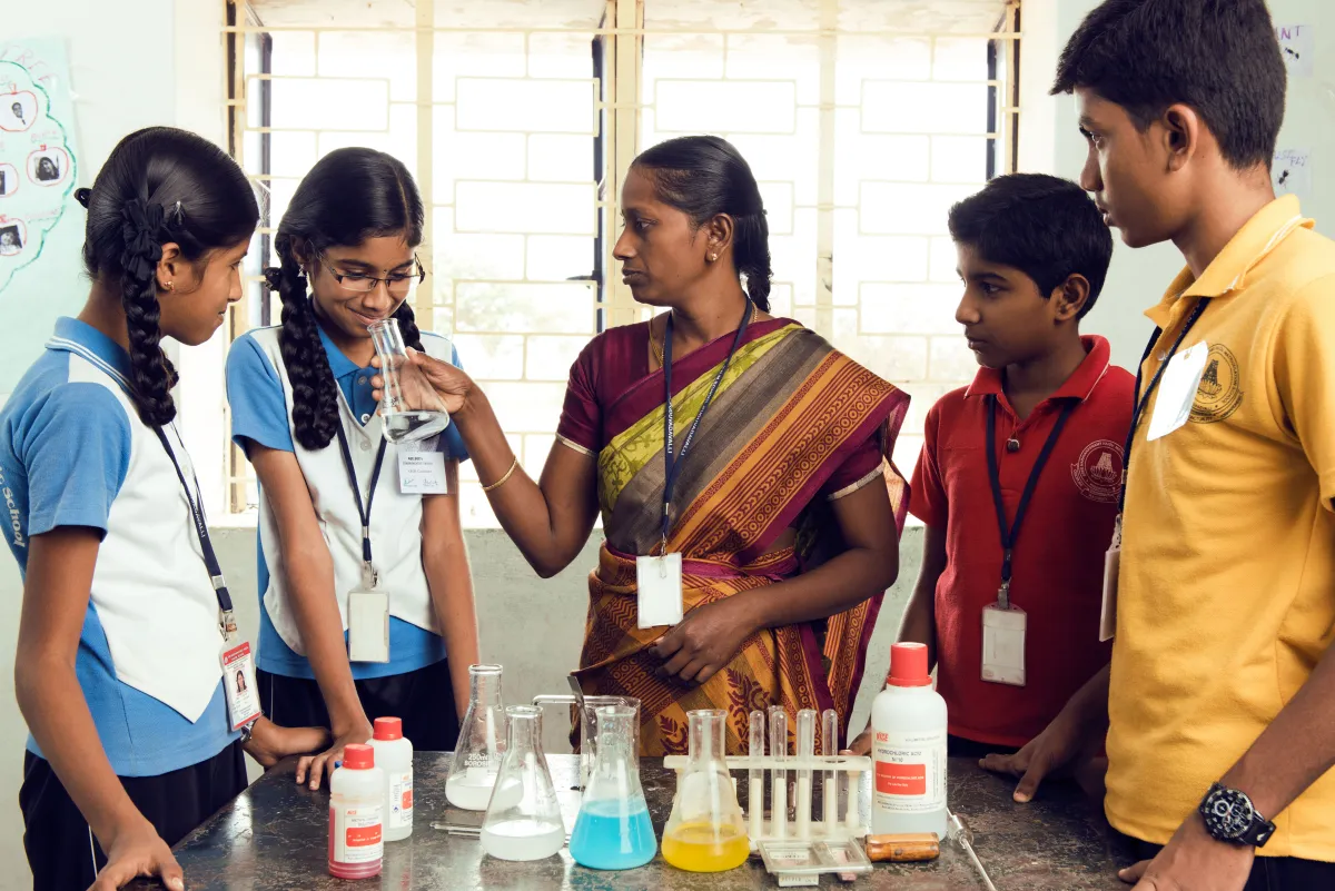 Teacher guiding students in the science lab
